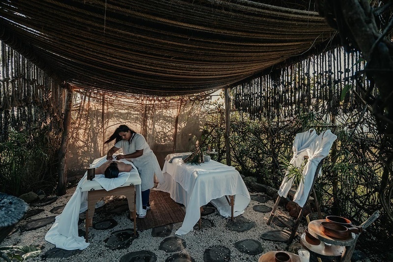 a woman is giving a man a massage under a canopy
