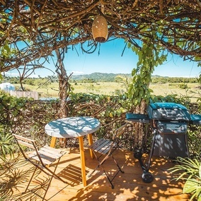 una mesa y sillas en un patio con una parrilla