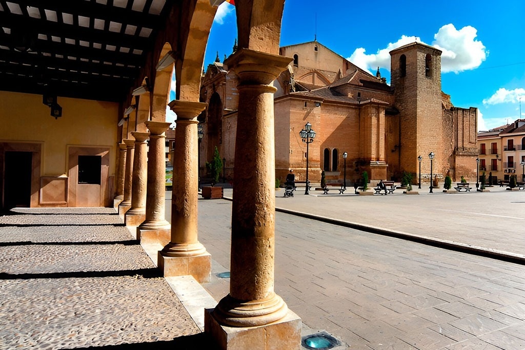 una iglesia con columnas y bancos frente a ella