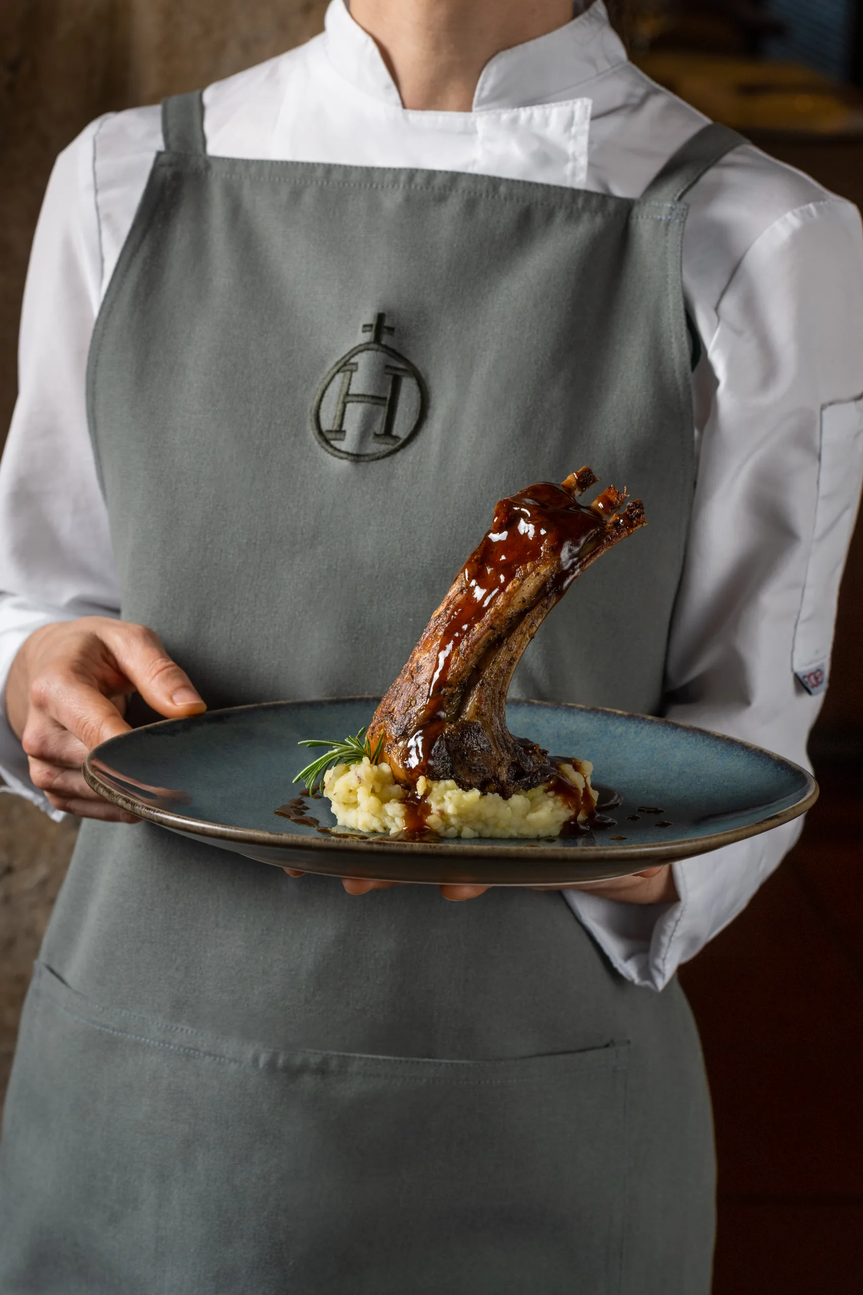 Chef presents a gourmet lamb dish with mashed potatoes and rosemary at Hacienda Zorita Wine Hotel.
