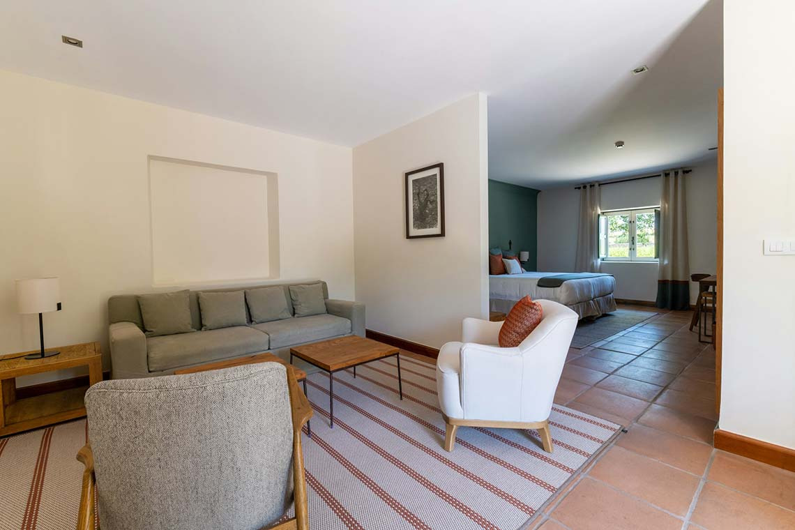 Amplia suite con sala de estar y dormitorio adjunto. Hacienda Zorita Wine Hotel con comodidades.