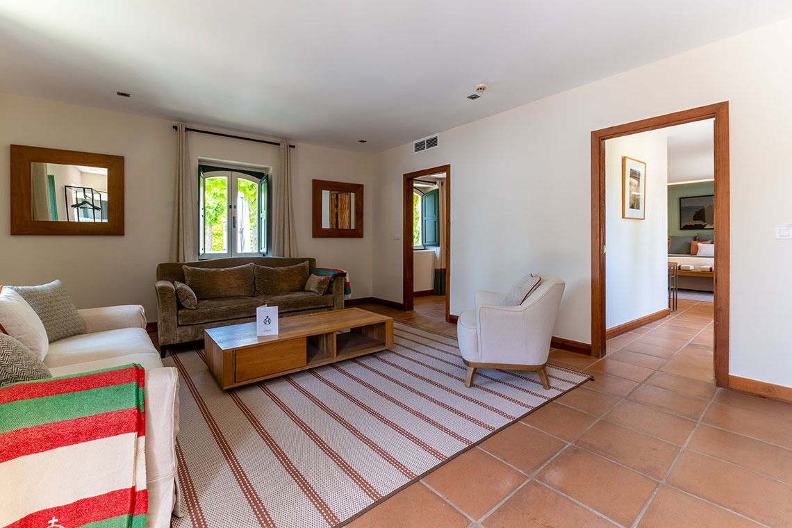 Sofá y sillón en sala de estar de hotel conHacienda Zorita Wine Hotel.