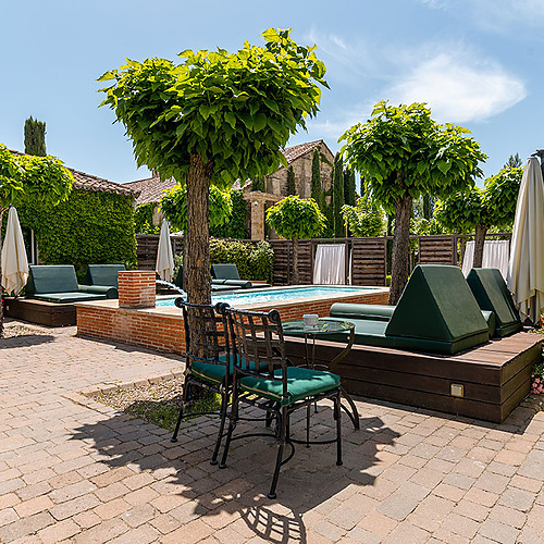 Piscina y tumbonas en patio de hotel, ideal para relajarse Hacienda Zorita Wine Hotel.