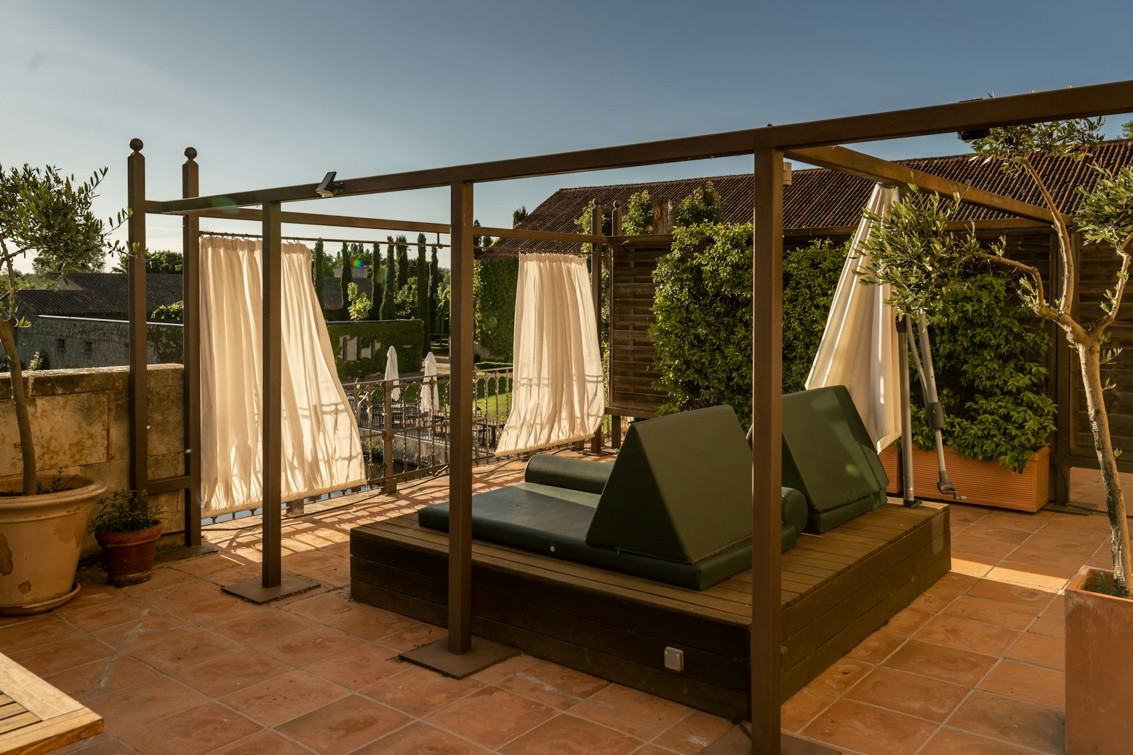 Terraza de hotel con tumbonas Hacienda Zorita Wine Hotel y vistas a jardín bajo un cielo azul.