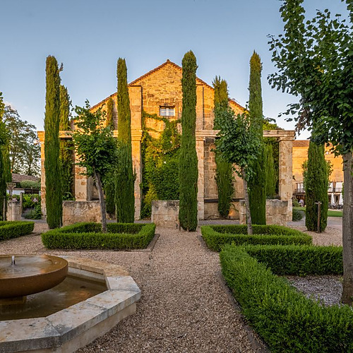 Jardín elegante de hotel con fuente, cipreses y arquitectura Hacienda Zorita Wine Hotel