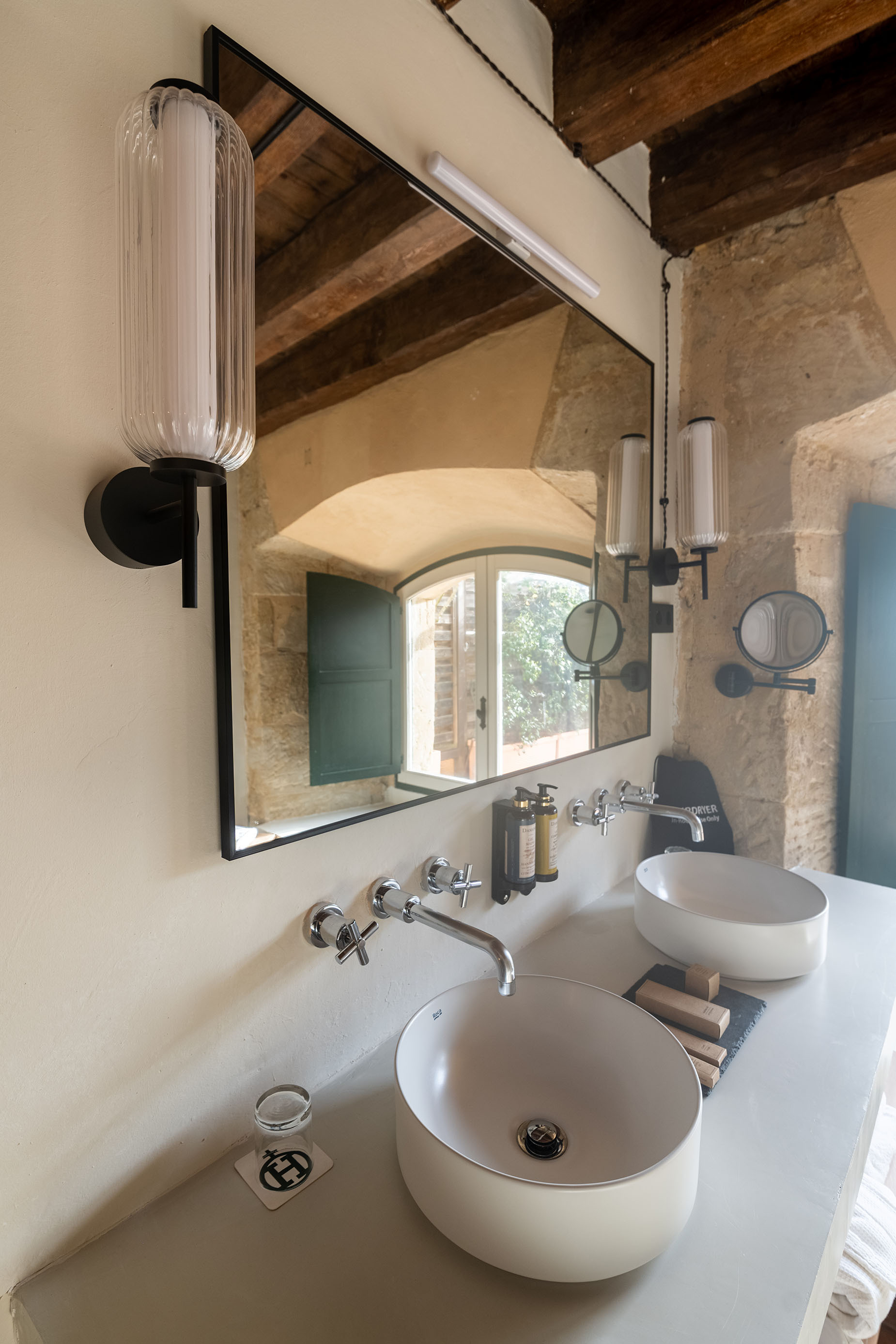 Doble lavabo moderno con espejo y luces en baño de hotel. Hacienda Zorita Wine Hotel