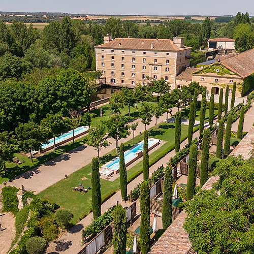 Hotel Hacienda Zorita Wine Hotel: Edificio histórico con piscina, jardines y cipreses.