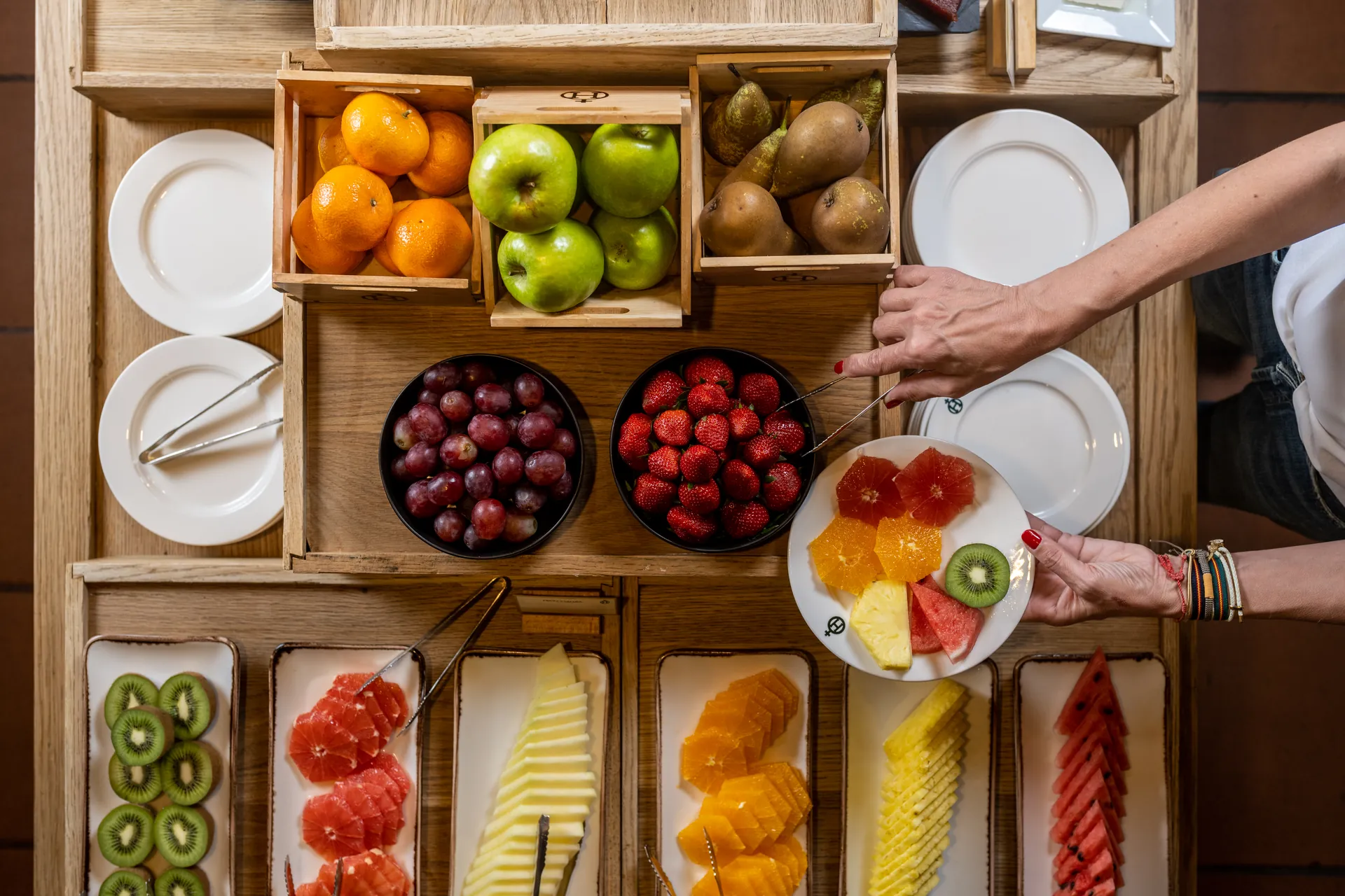 A vibrant fruit buffet at a hotel, featuring a selection of fresh Hacienda Zorita Wine Hotel, citrus, and berries.