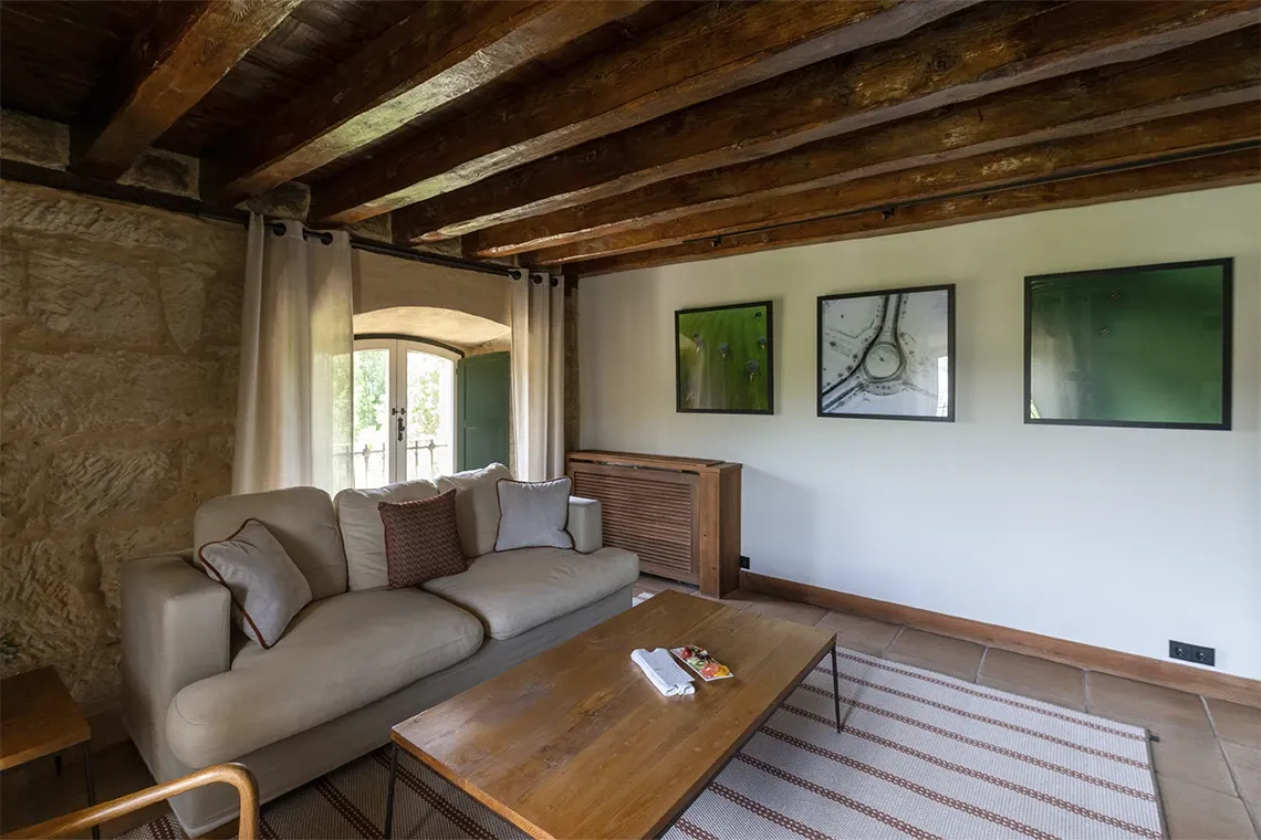Salón acogedor con sofá, vigas de madera yHacienda Zorita Wine Hotel.