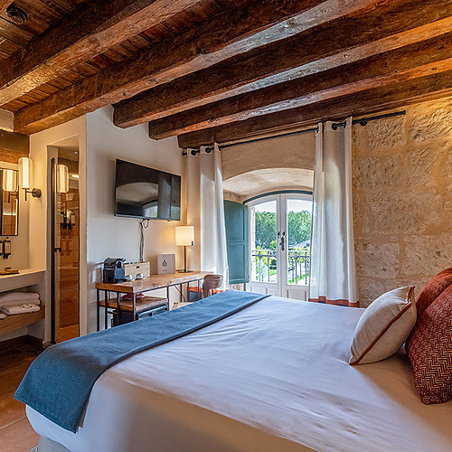 Amplia y luminosa habitación de hotel con cama King Size, sala de estar y decoración rústica, ideal para Hacienda Zorita Wine Hotel