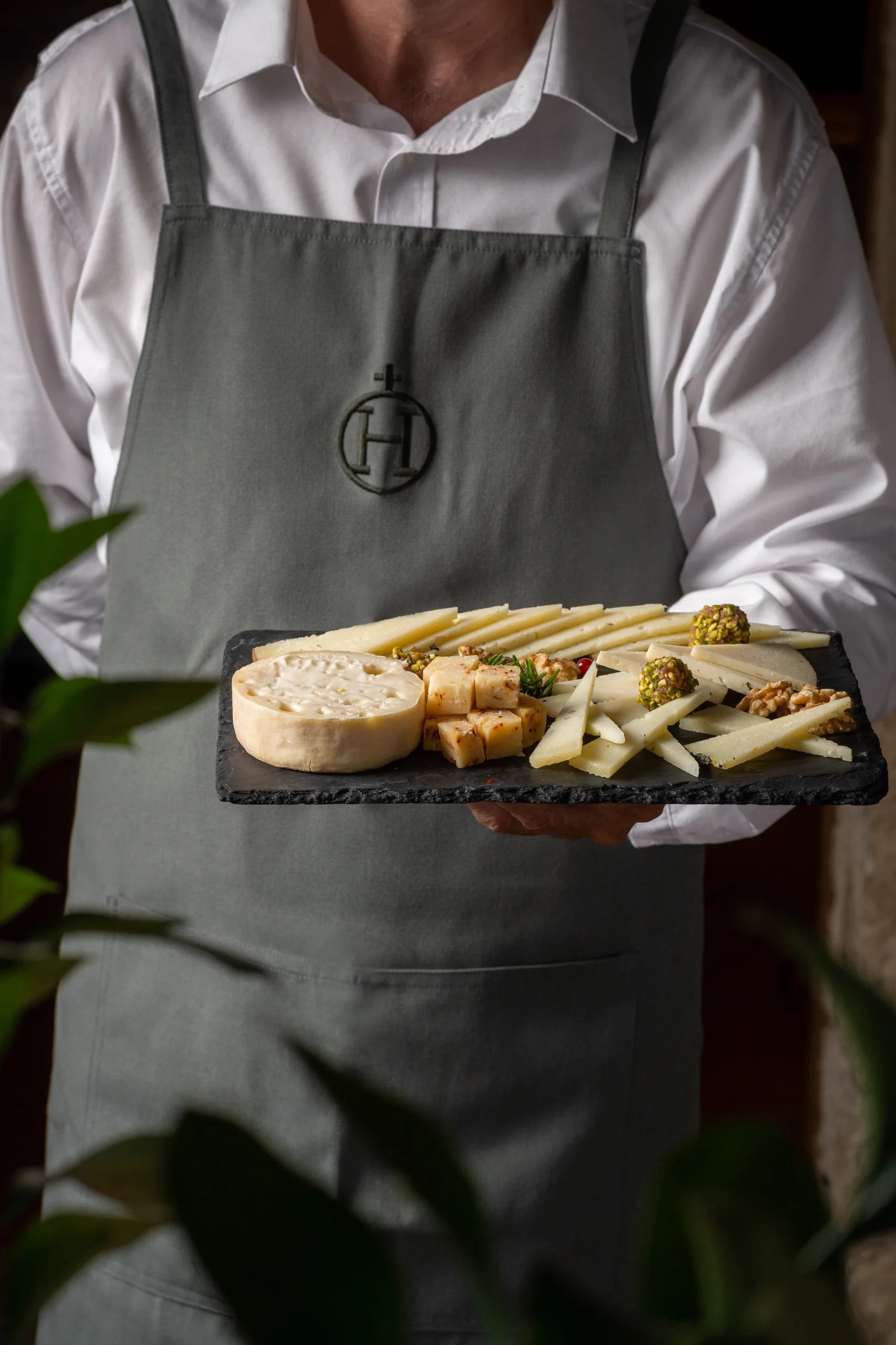 Chef serves a cheese Hacienda Zorita Wine Hotel platter with pistachios and nuts.