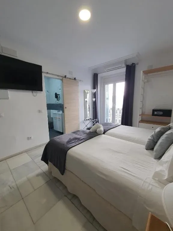 HEMD: Modern living area with sofa, TV, and balcony in hotel.