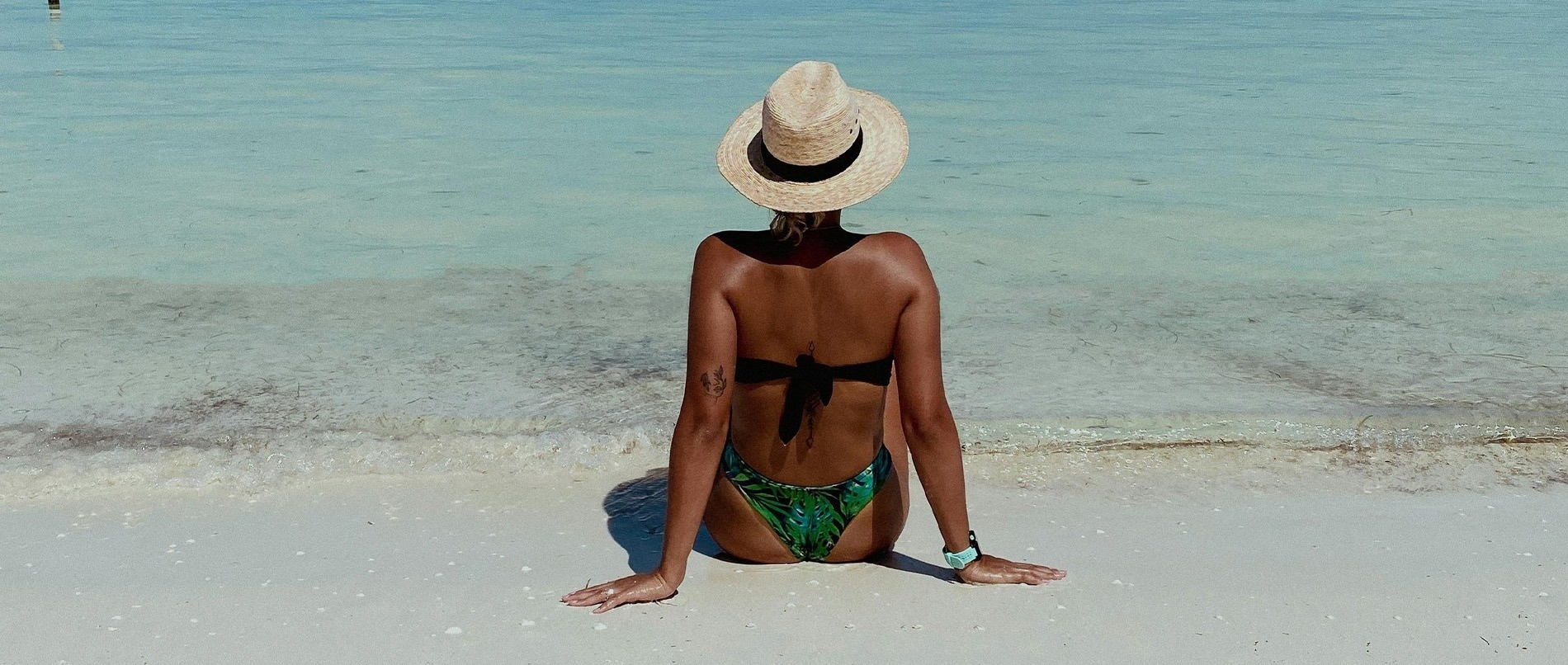 un paraguas colorido en la playa con el océano en el fondo