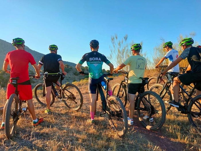 Huéspedes disfrutan ciclismo de montaña en paisajes naturales. Actividades al aire libre del hotel.