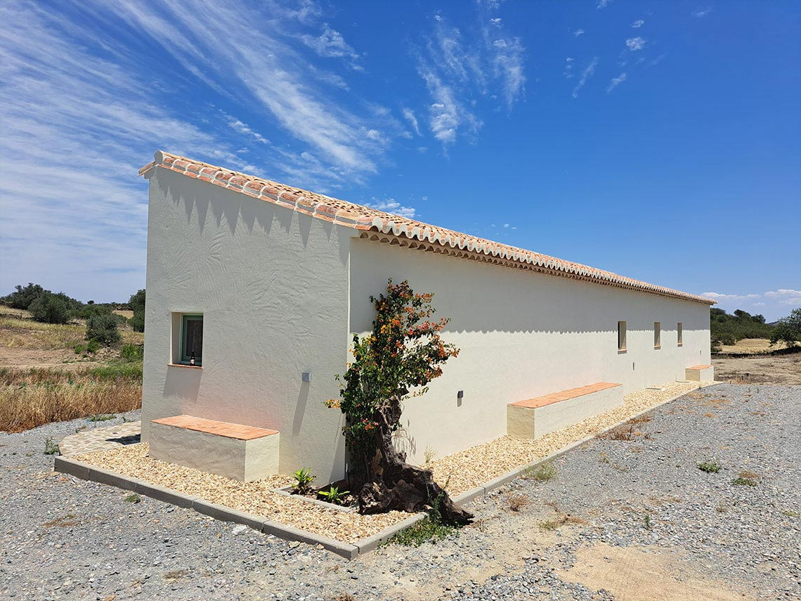 Casa rural Horta de Bufenha com telhado de terracota e céu azul.