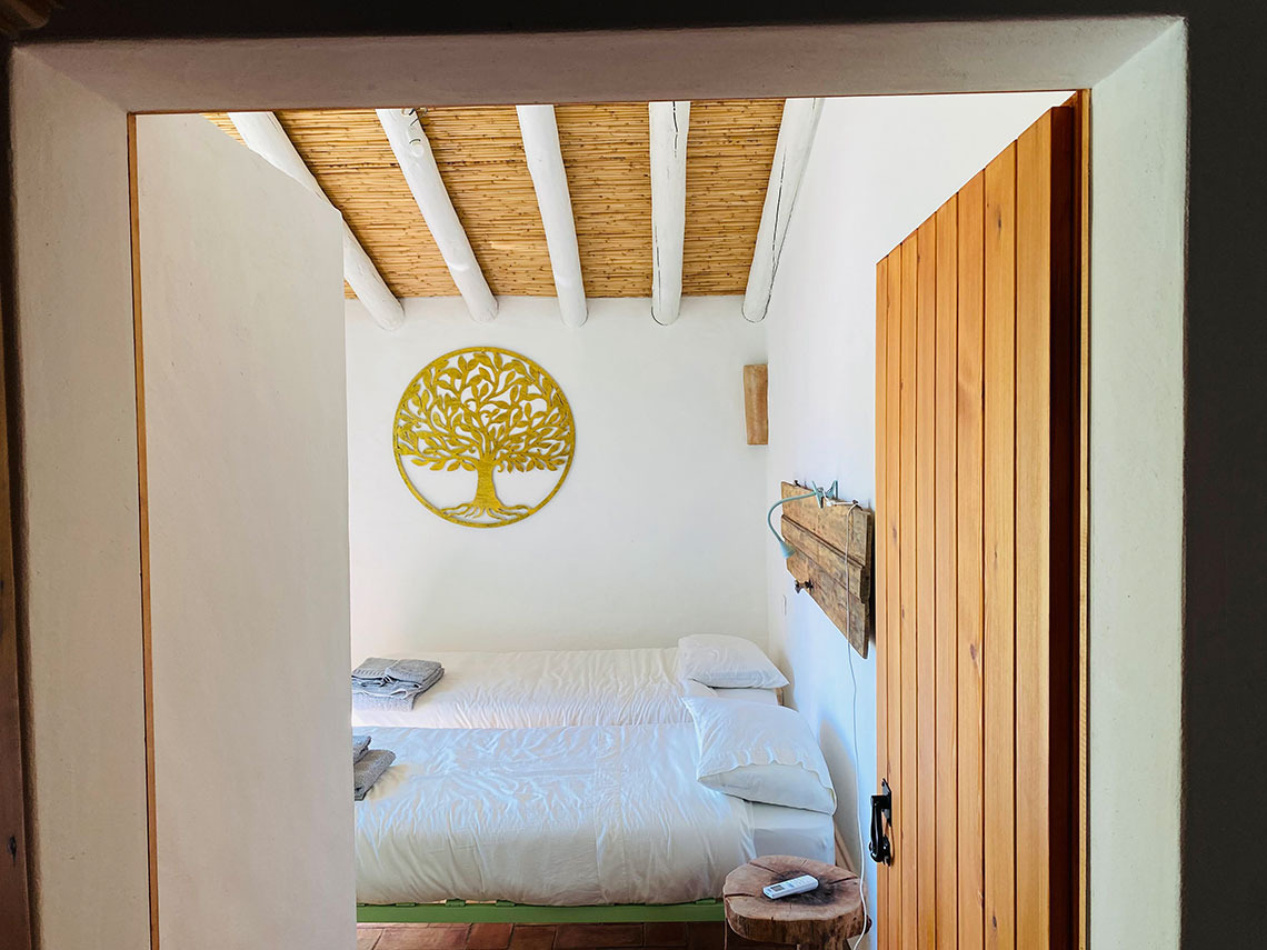 Quarto twin com decoração de árvore da vida,Horta de Bufenha, porta de madeira rústica e teto de bambu.