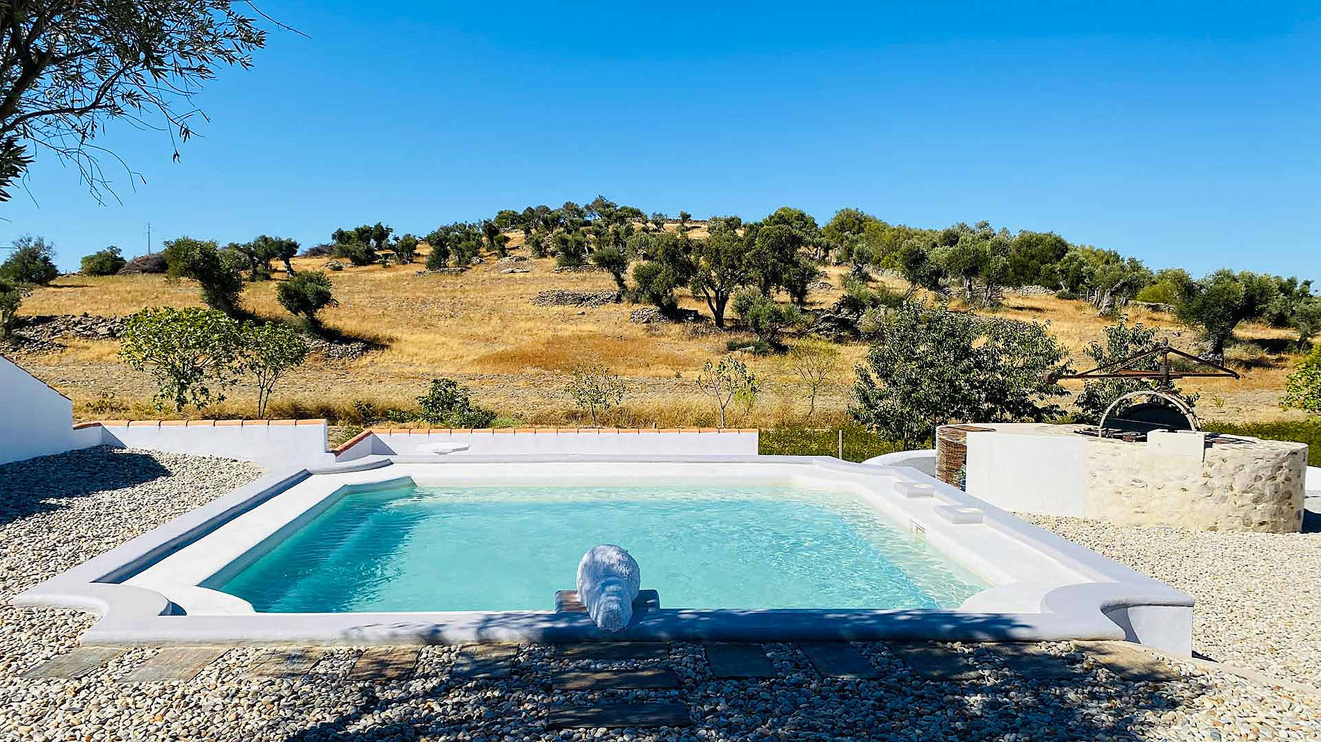 Piscina serena com colinas verdejantes ao fundo, ideal para o seu Horta de Bufenha de férias.