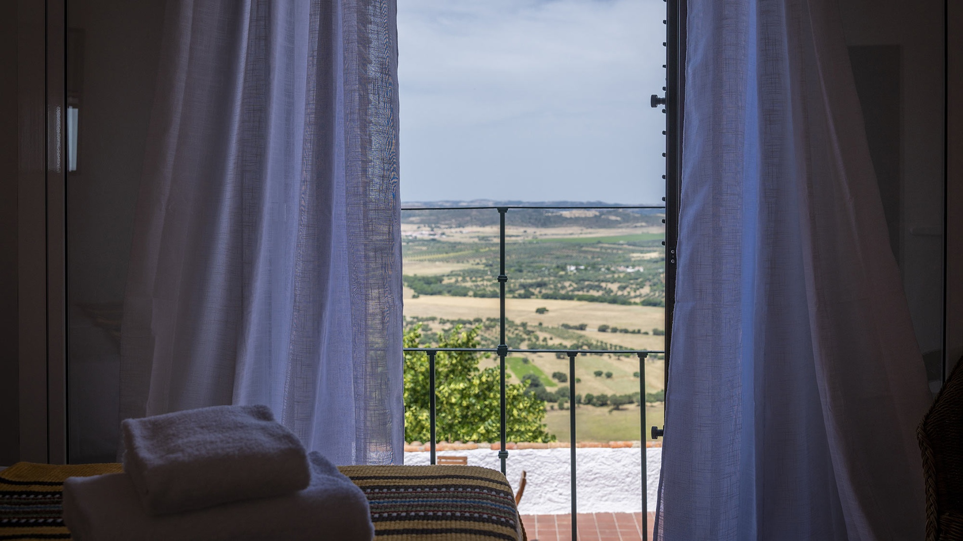 Vista desde Horta da Moura: paisaje rural, balcón y cortinas.