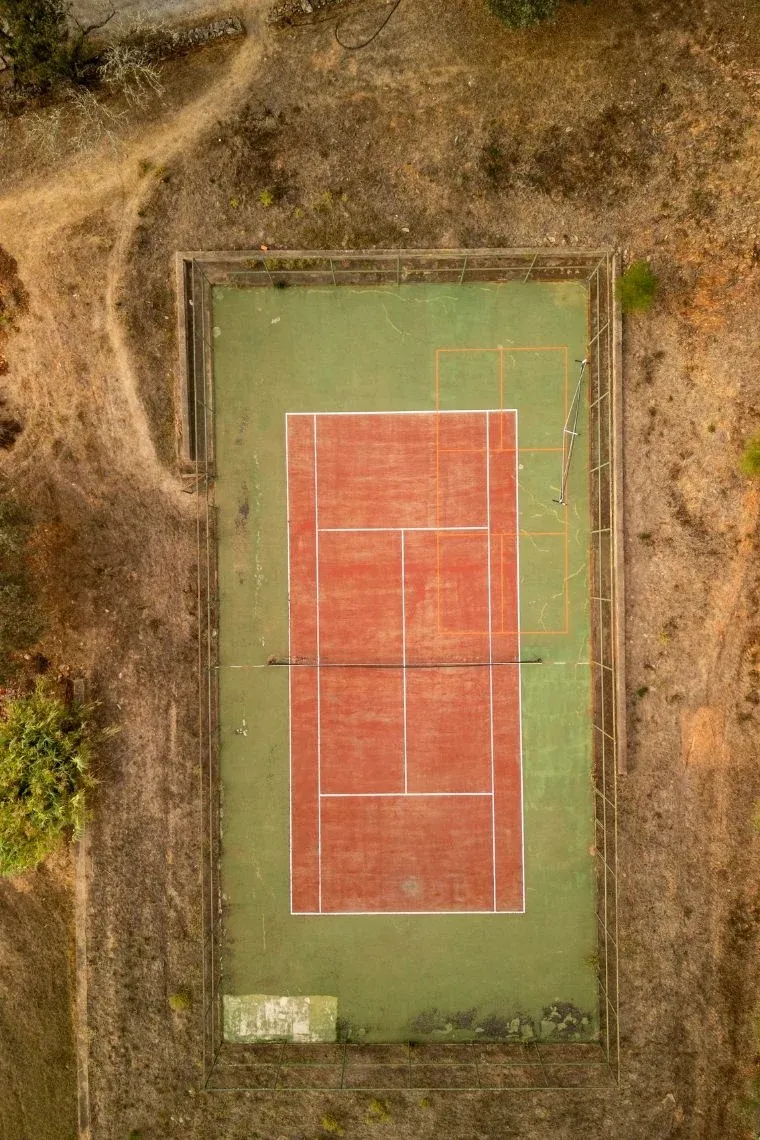 Aerial view of a tennis court at Horta da Moura, offering outdoor recreation.