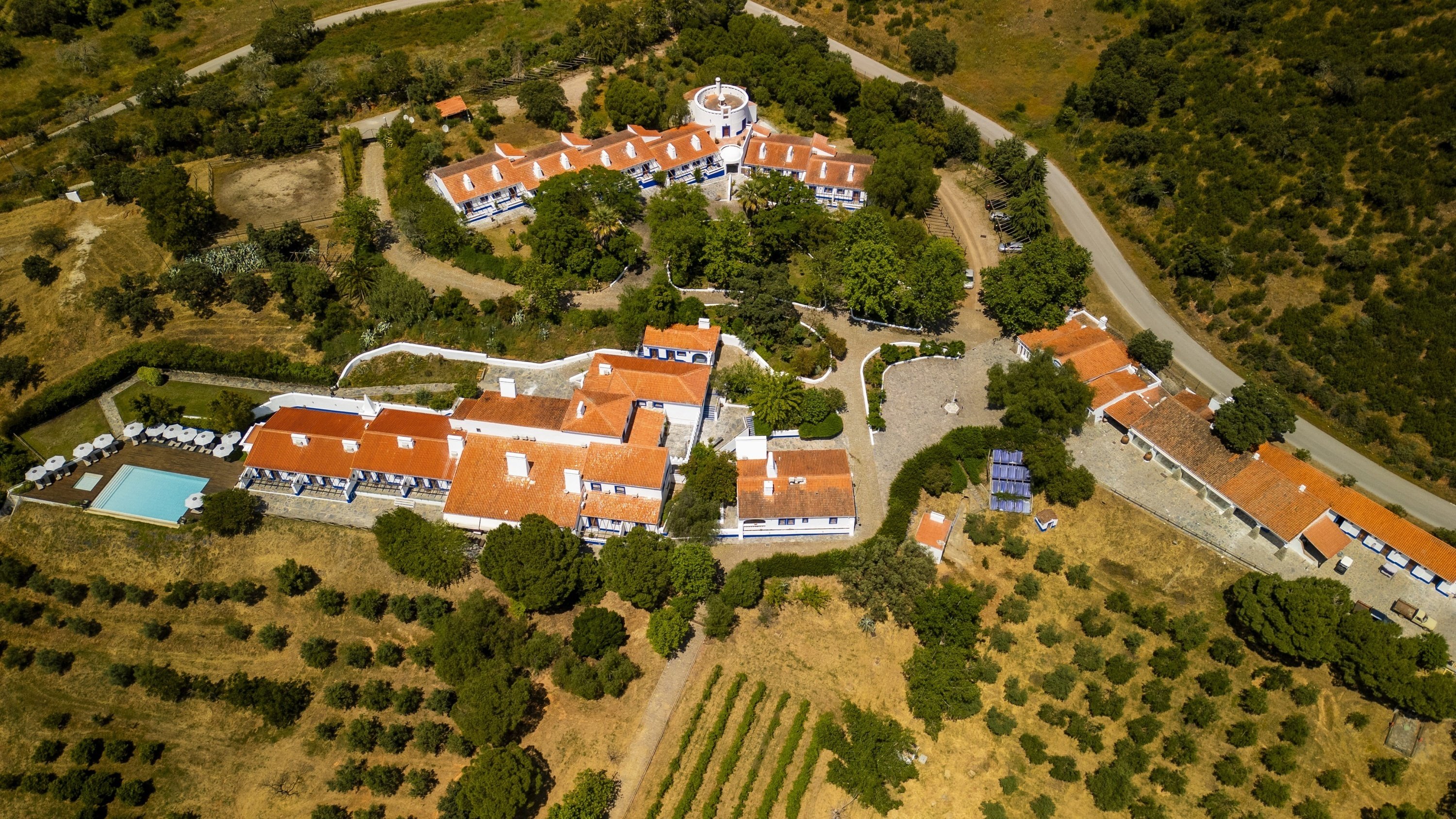 uma pequena rua entre duas casas brancas com telhados de telhas vermelhas