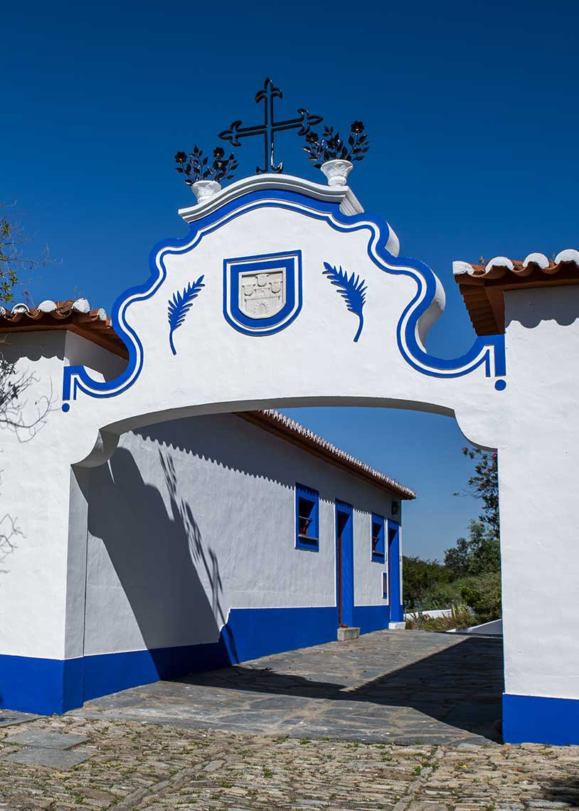 Entrance to Horta da Moura with white architecture and blue details.