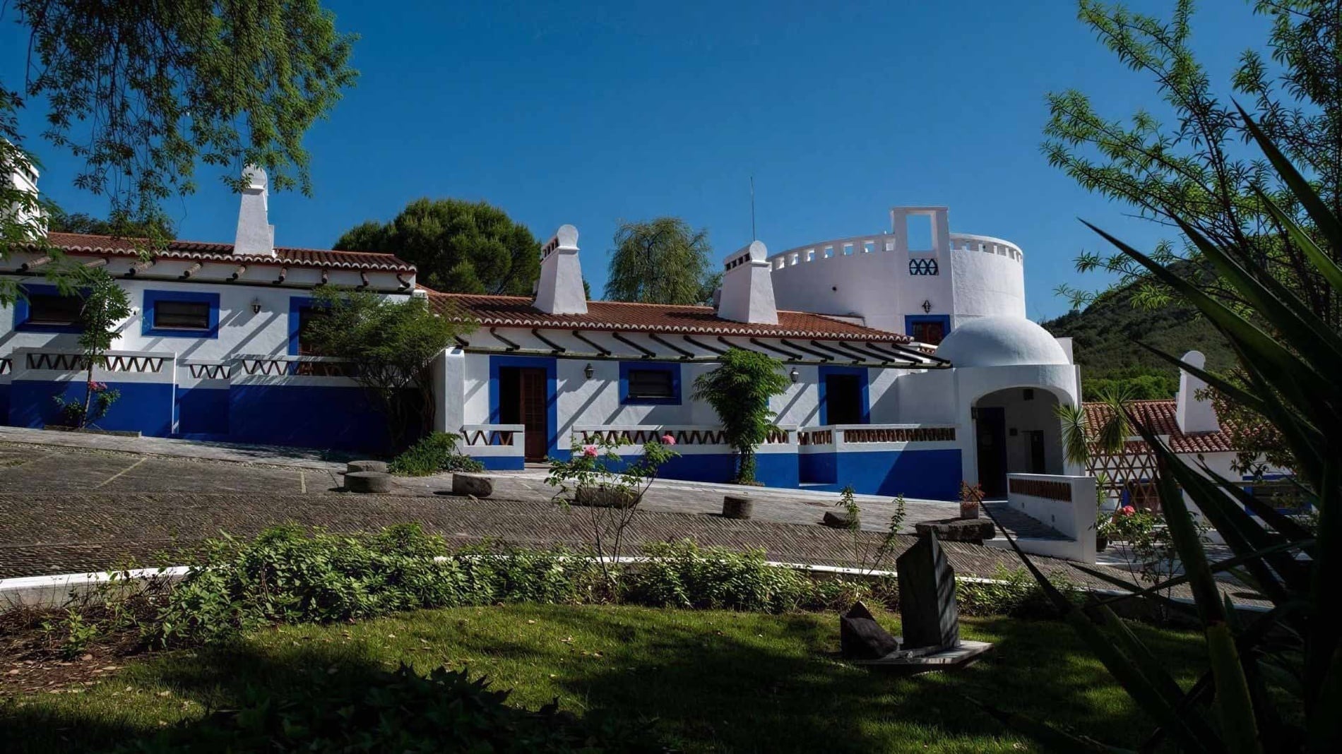 Charming Horta da Moura hotel with blue and white architecture and lush greenery.