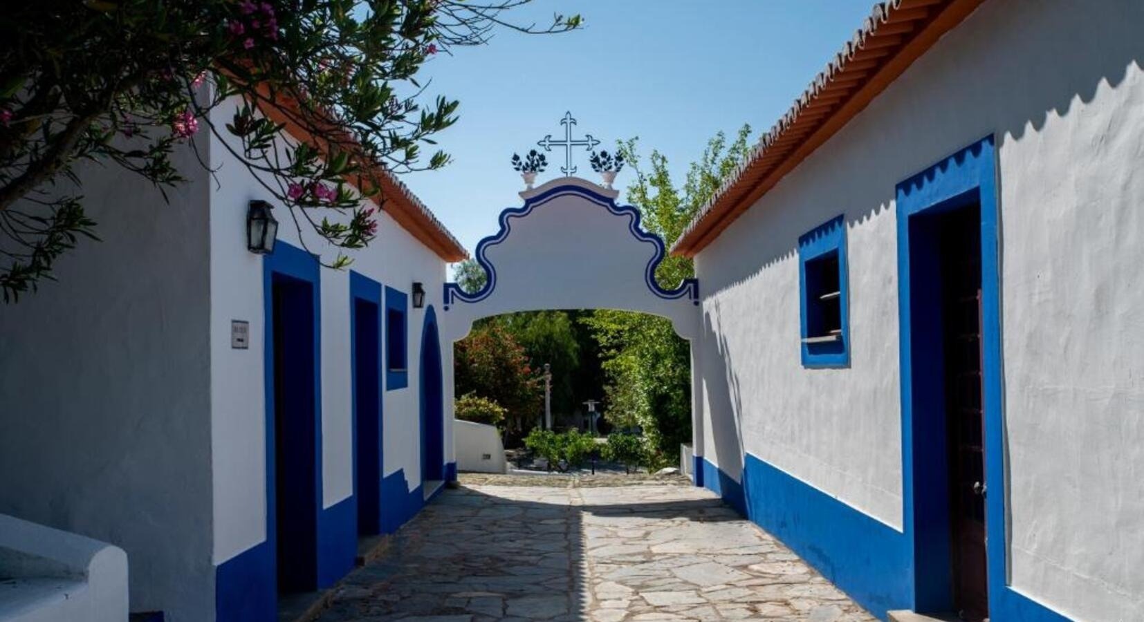Horta da Moura: Arquitetura pitoresca com arco e casas caiadas de branco e azul.