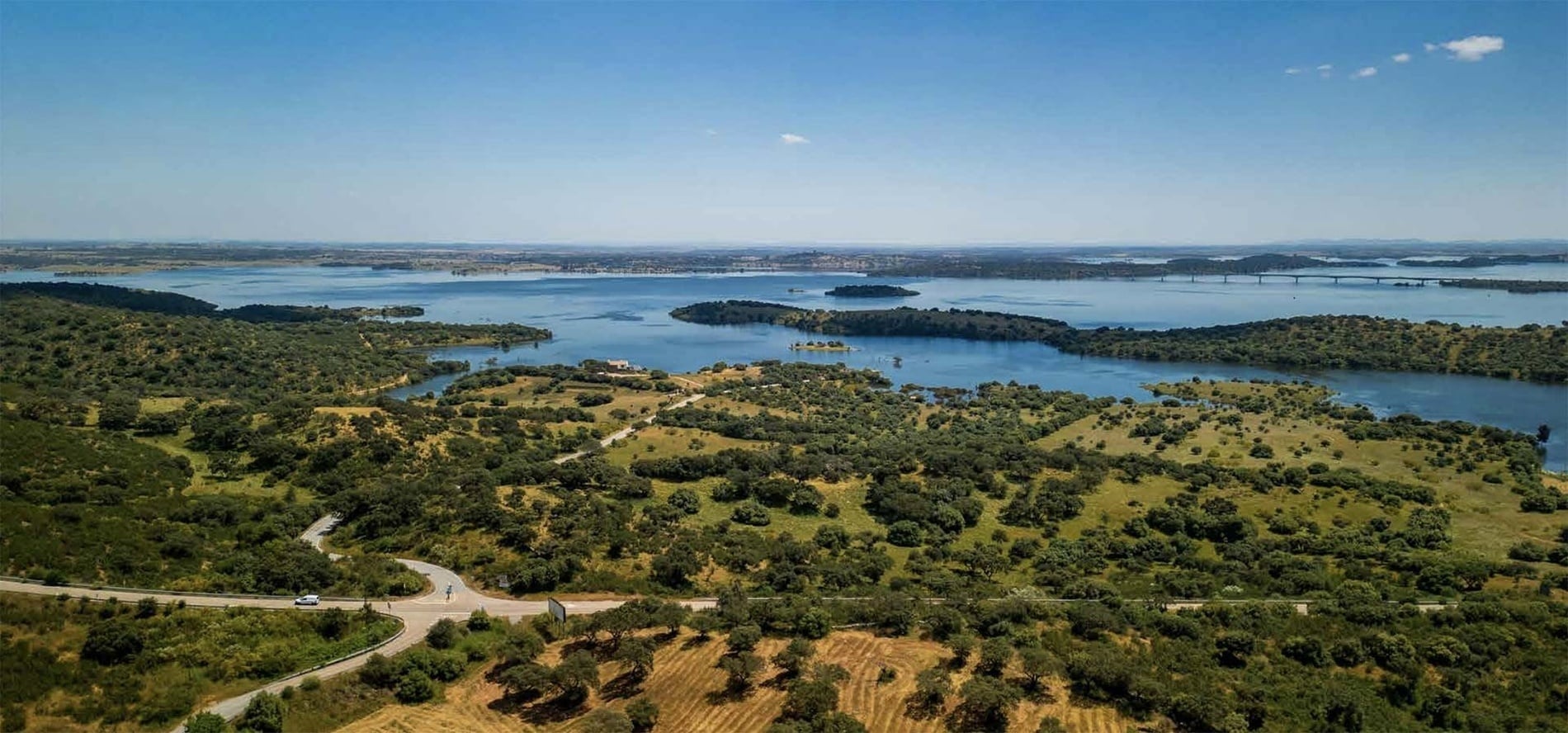 Scenic Horta da Moura landscape with lake and rolling hills.