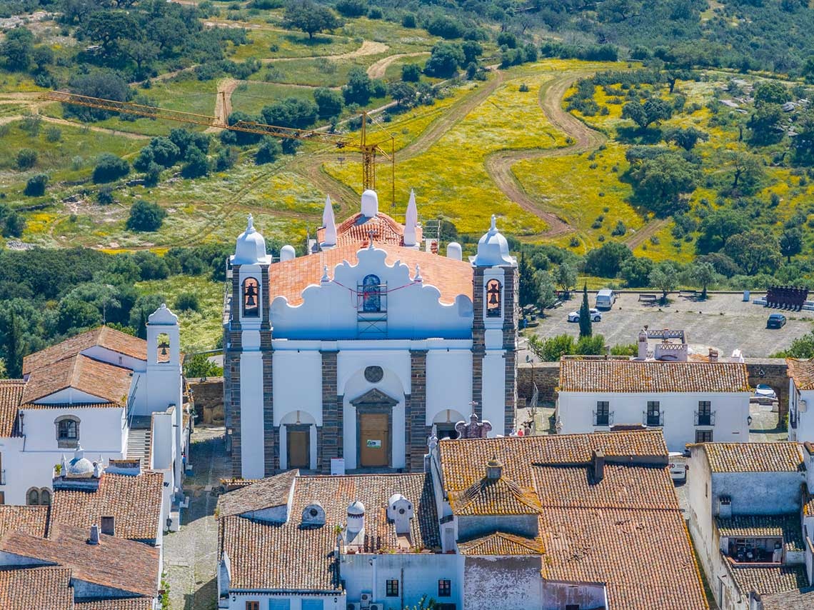 Vista aérea de una hermosa iglesia y vista de los tejados desde un mirador panorámico en Alqueva.
