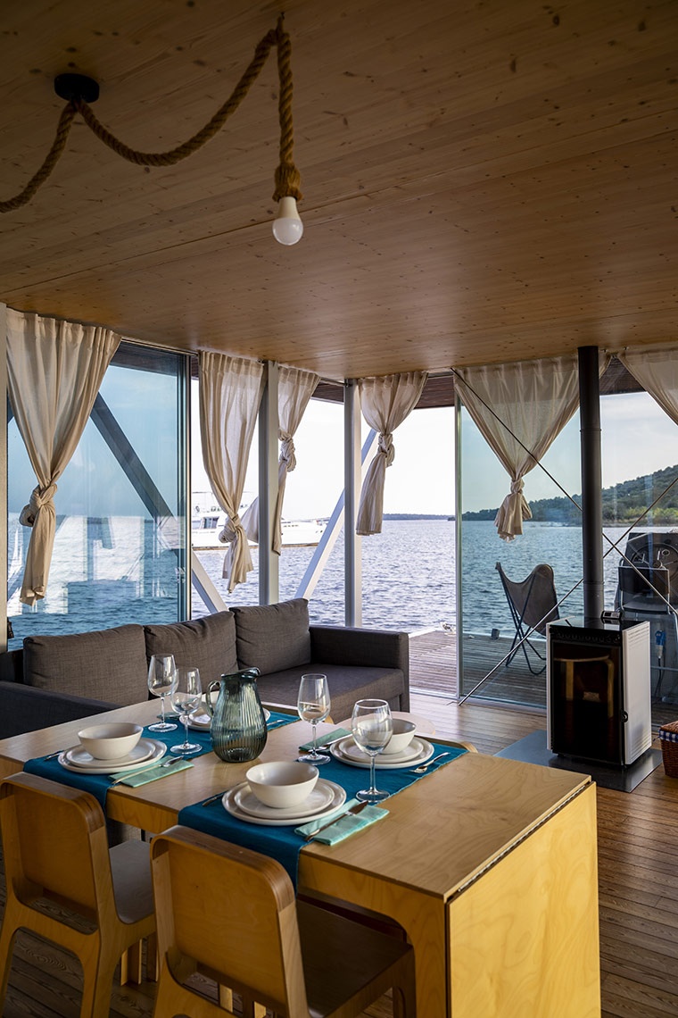 Sala do Casa Aqua, com mesas com pratos e vista para o mar.