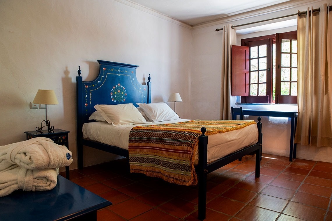 uma casa branca com uma porta vermelha e uma mesa e cadeiras