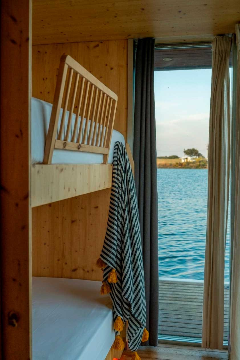 Cozy Horta da Moura suite with lake views, natural light, and rustic decor.