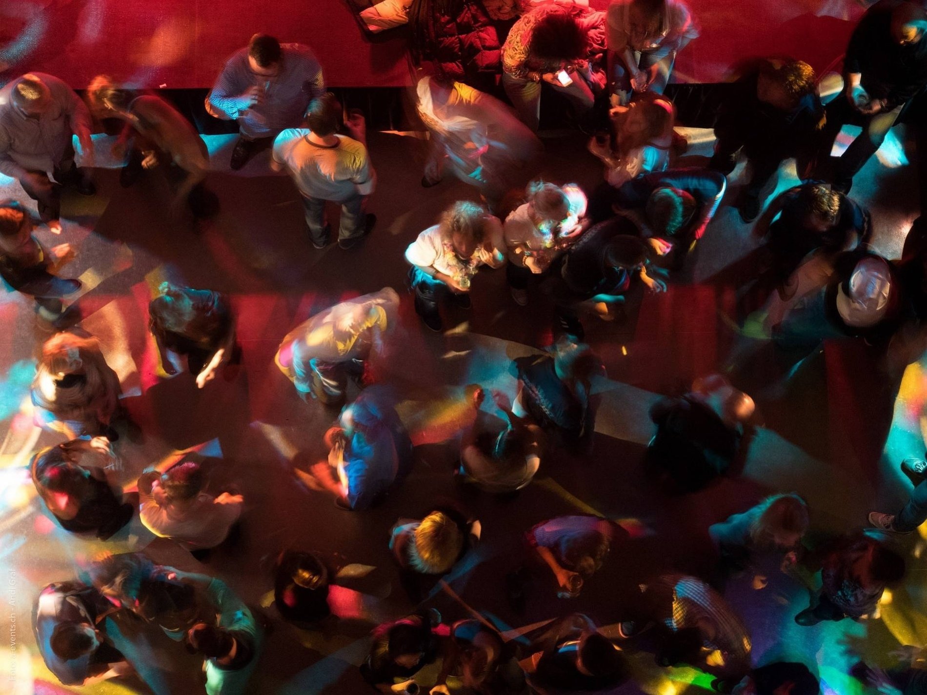 a crowd of people are dancing in a dark room