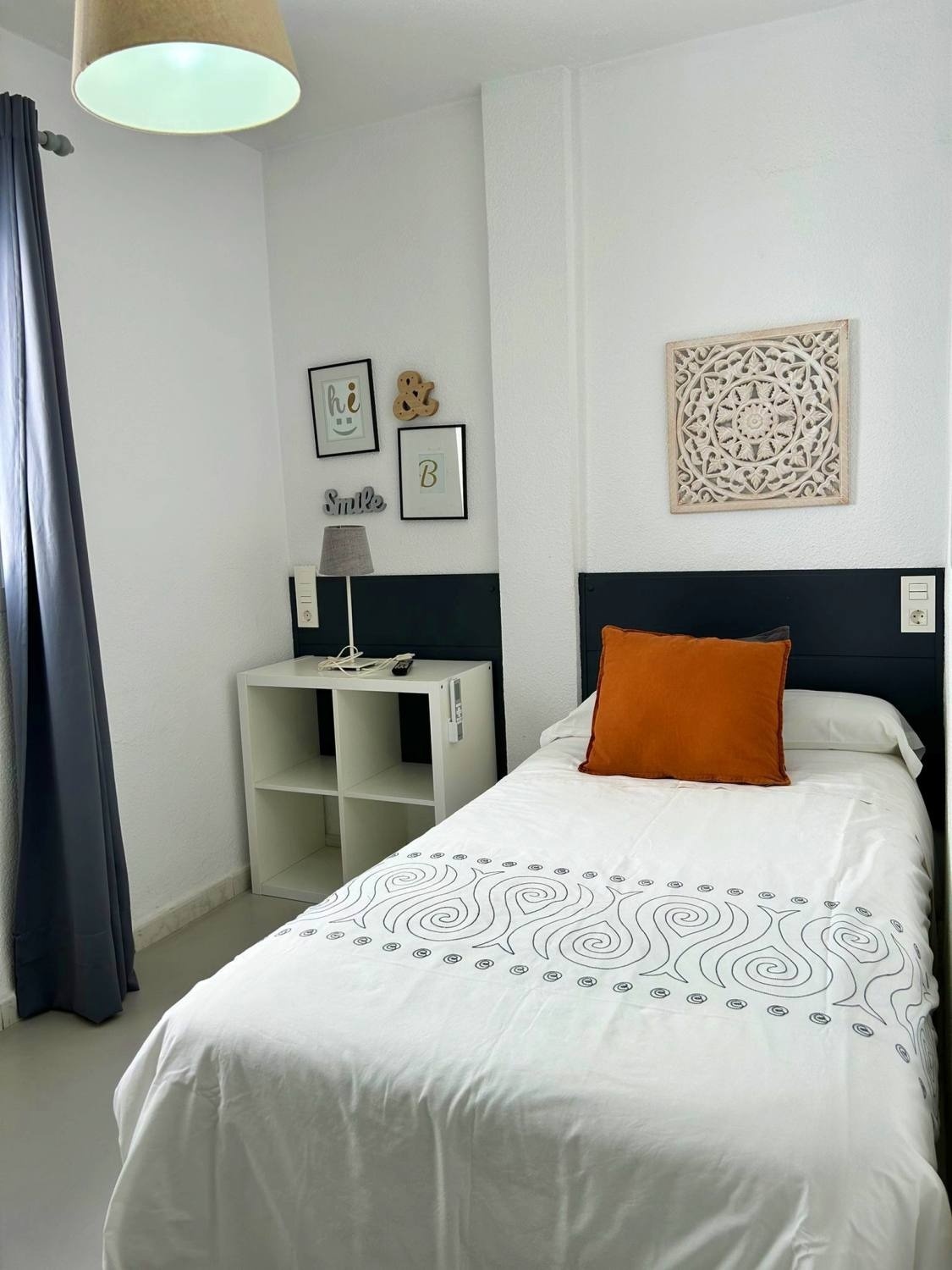 una habitación con una cama y una lámpara y un cartel que dice hi & smile