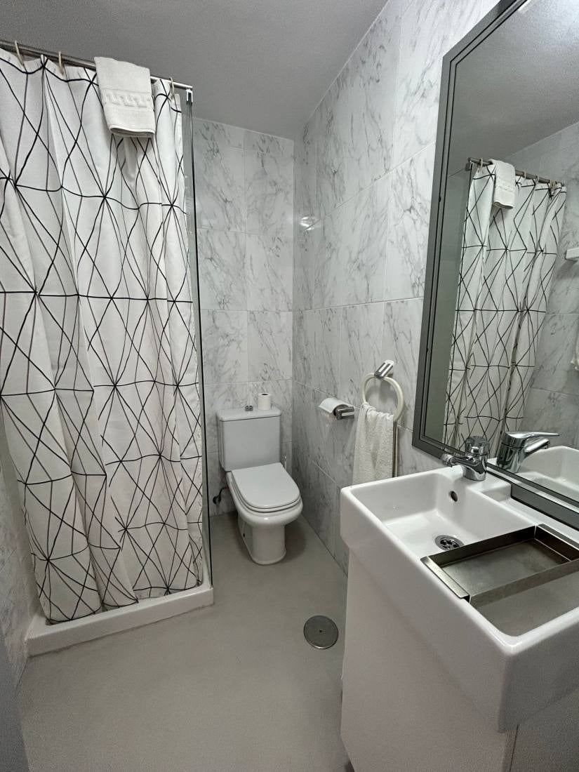 a bathroom with a toilet a sink and a shower curtain