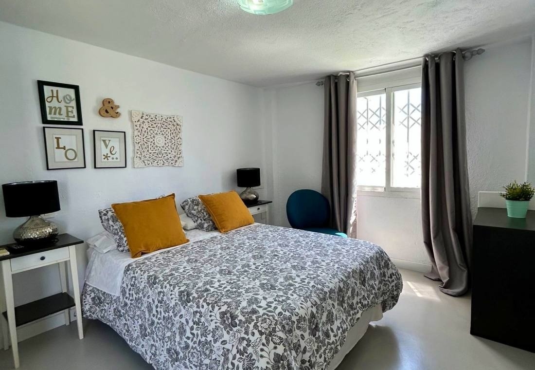 una habitación blanca con una cama y una silla