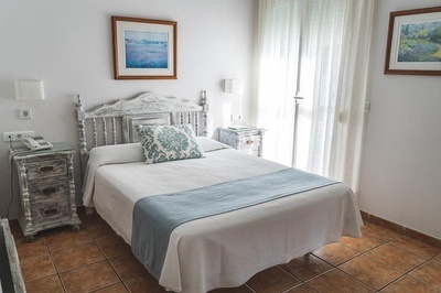 a bedroom with a bed and two nightstands and a picture on the wall above the bed