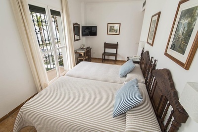 a bedroom with two beds and a television on the wall