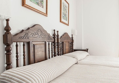 a bed with a wooden headboard and a striped blanket