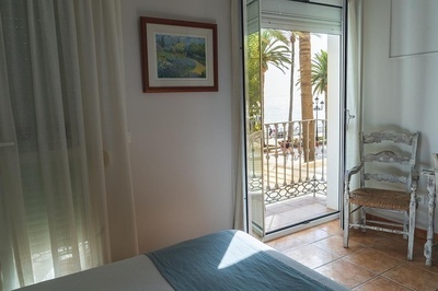 a bedroom with a balcony and a painting on the wall