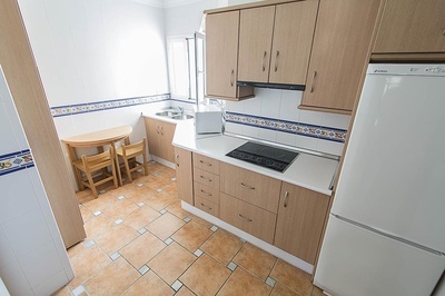 una cocina con gabinetes de madera y una nevera blanca