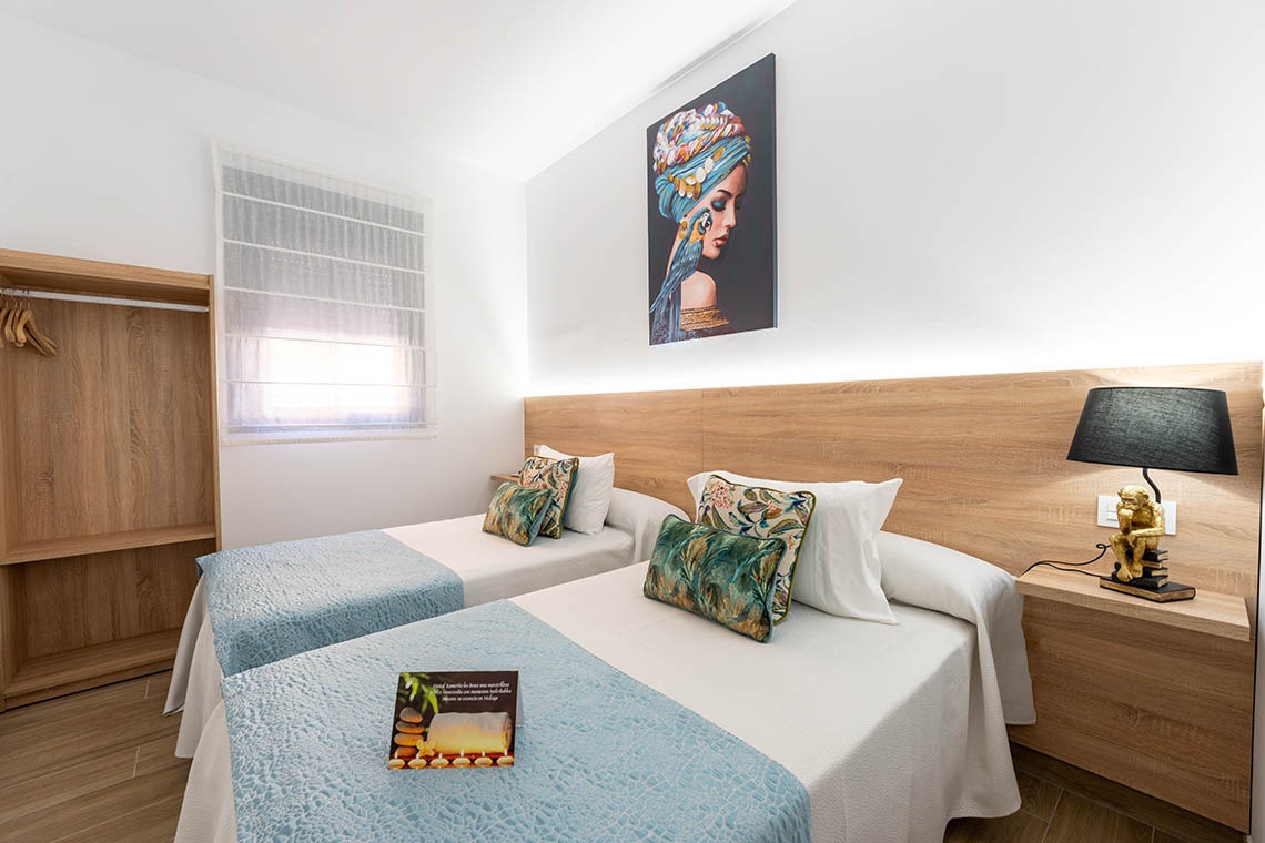 una habitación con dos camas y una pintura en la pared