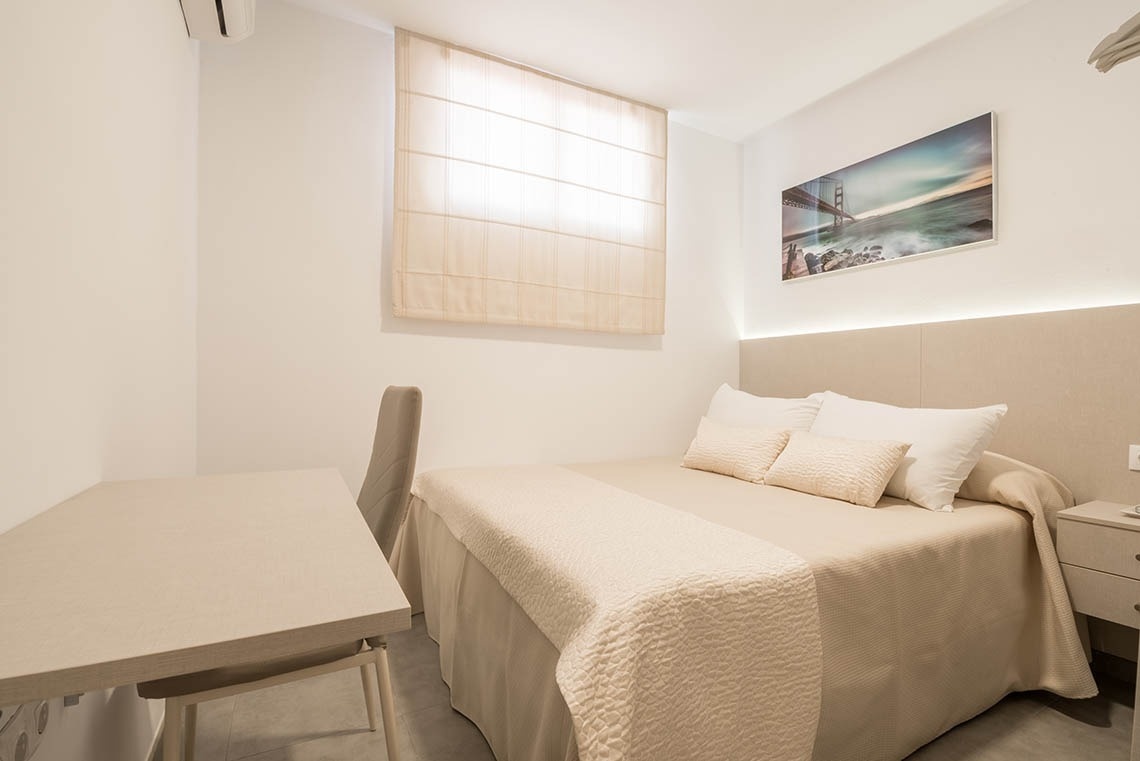 una habitación con tres camas y una pintura de un muelle en la pared