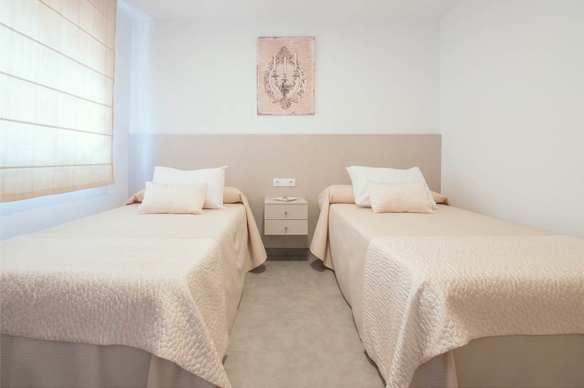un dormitorio con dos camas y un cuadro en la pared