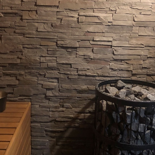 una sauna con una pared de ladrillos y un barril de piedra