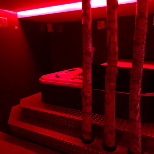 a hot tub in a dark room with red lights