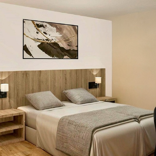 una habitación con una cama y una pintura en la pared
