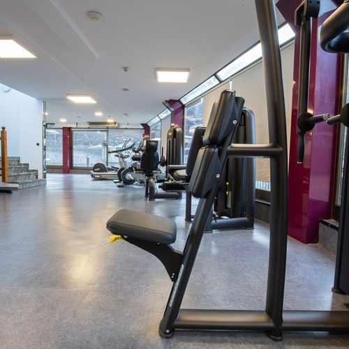 a gym with a purple wall and a staircase