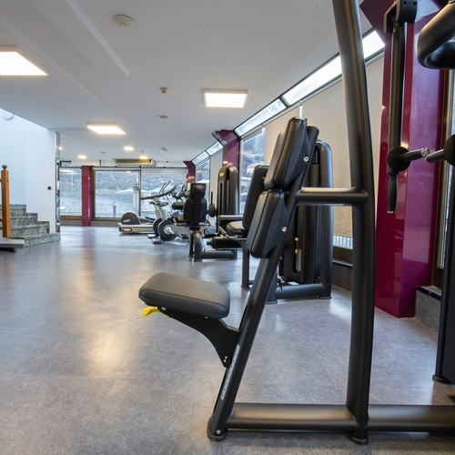 una sala de gimnasia llena de maquinaria y escaleras