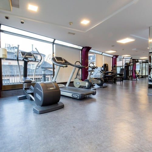 a gym with a treadmill that says technogym on it